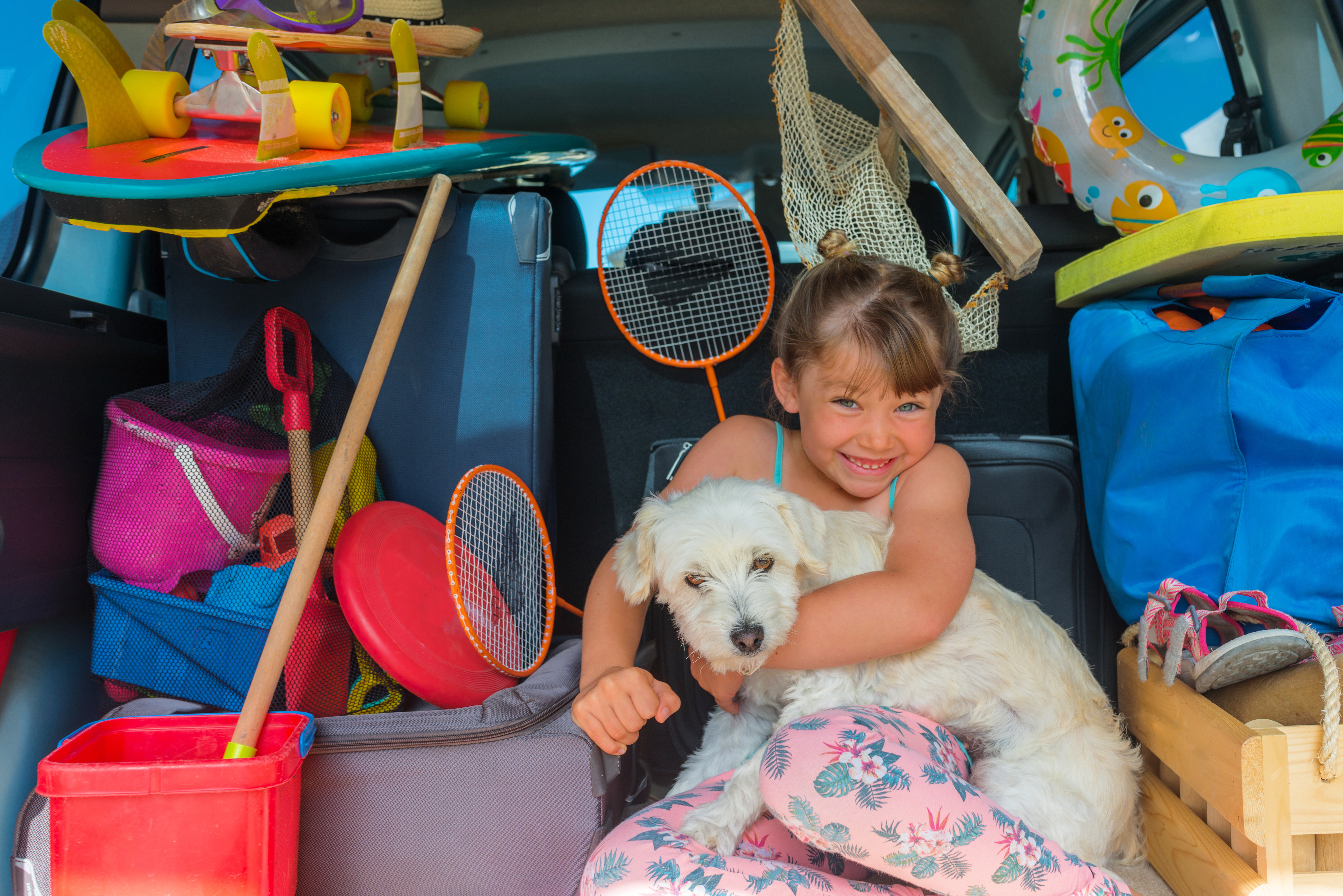 Überladener Kofferraum mit Gepäck, Kind und Hund