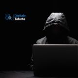 Hacker im Dunkeln und Kapuze vor Laptop