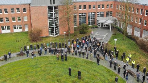 Viele Personen stehen zur Schweigeminute vor dem Bielefelder Polizeipräsidium.