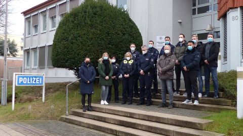 Mehrere Personen stehen zur Schweigeminute vor der Polizeiwache Süd.