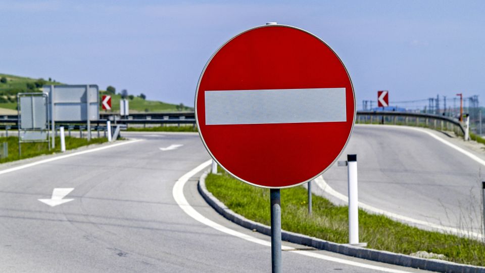 Das Foto zeigt im Vordergrund das Verkehrsschild  "Verbot der Einfahrt", im Hintergrund ist eine Autobahnausfahrt zu sehen.